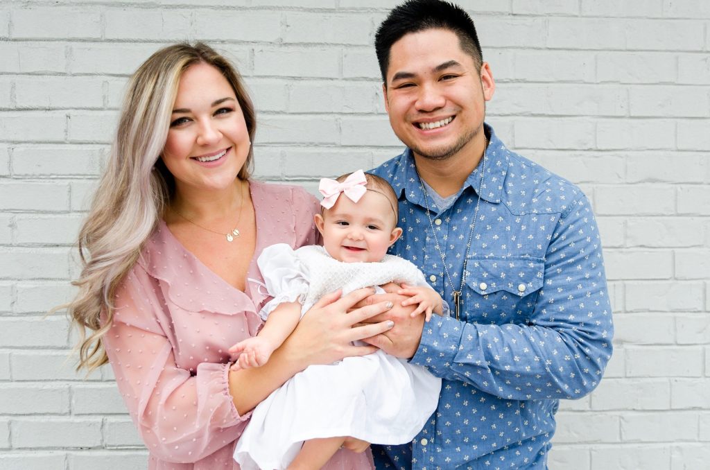 two parents with their baby pose for a photo