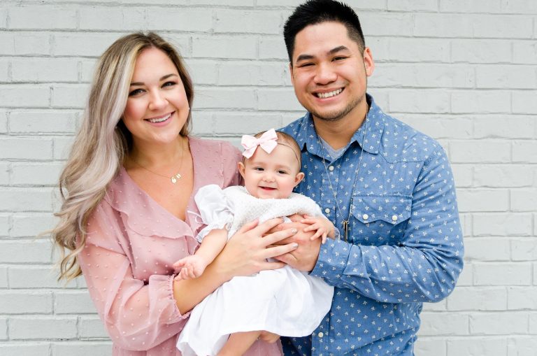 two parents with their baby pose for a photo