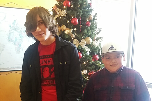 adolescent boys Marco and Isaiah in front of christmas tree